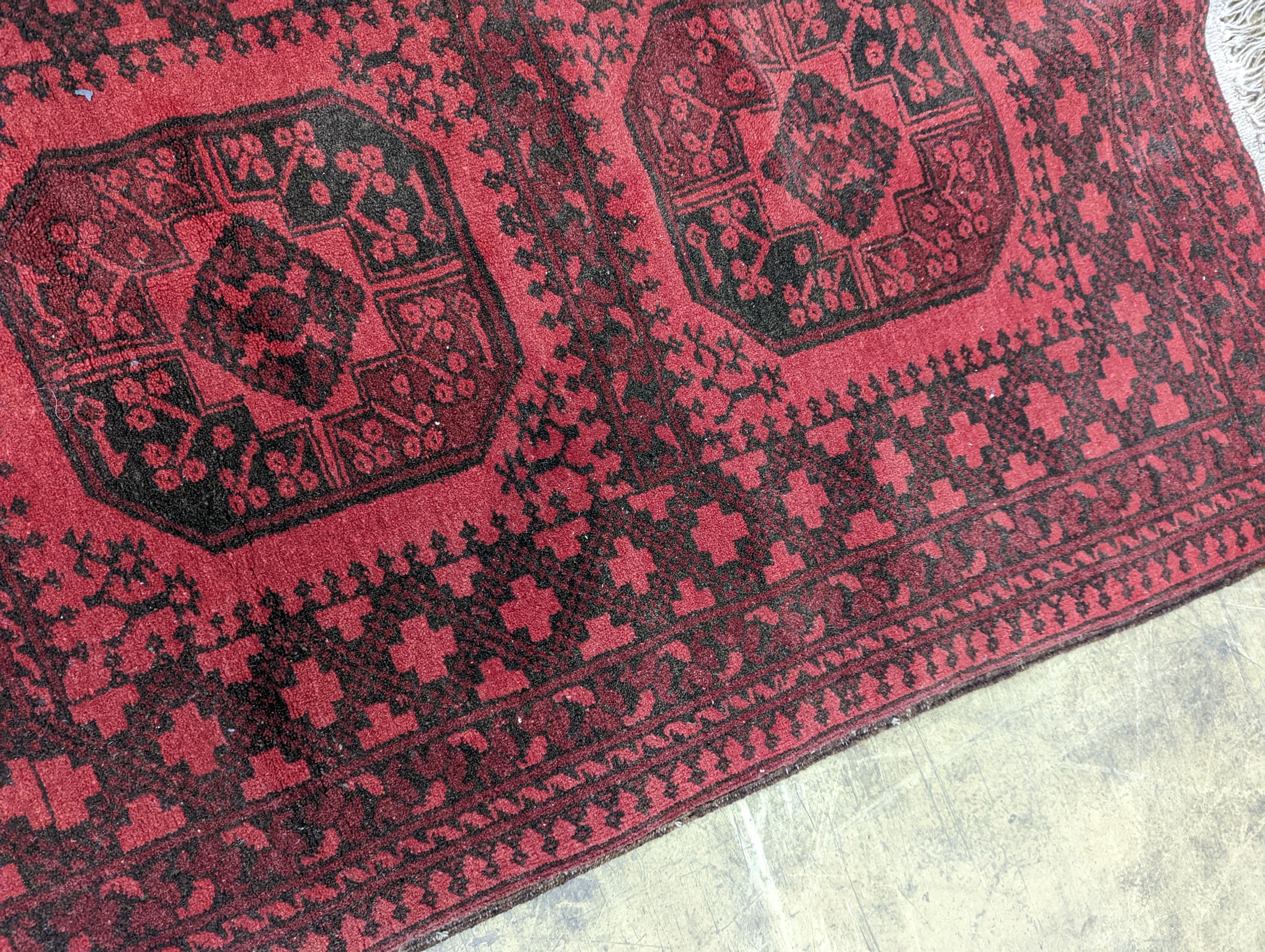 An Afghan red ground rug, 140 x 96cm